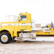 White Freightliner semi-truck parked at a truck stop, ready for long-haul transport